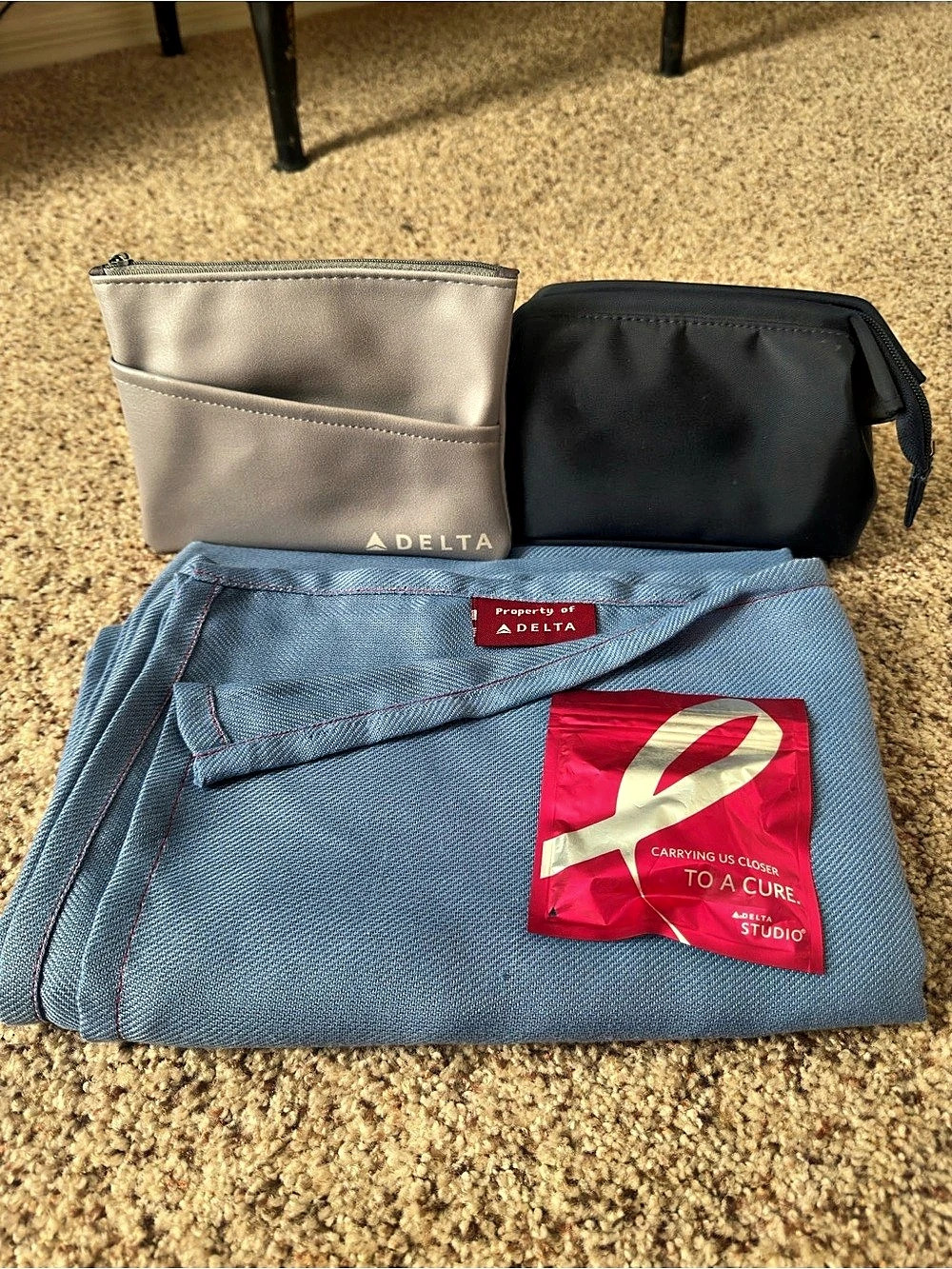 Delta Airlines amenity kit pouches, blanket, and breast cancer earbuds 🩷